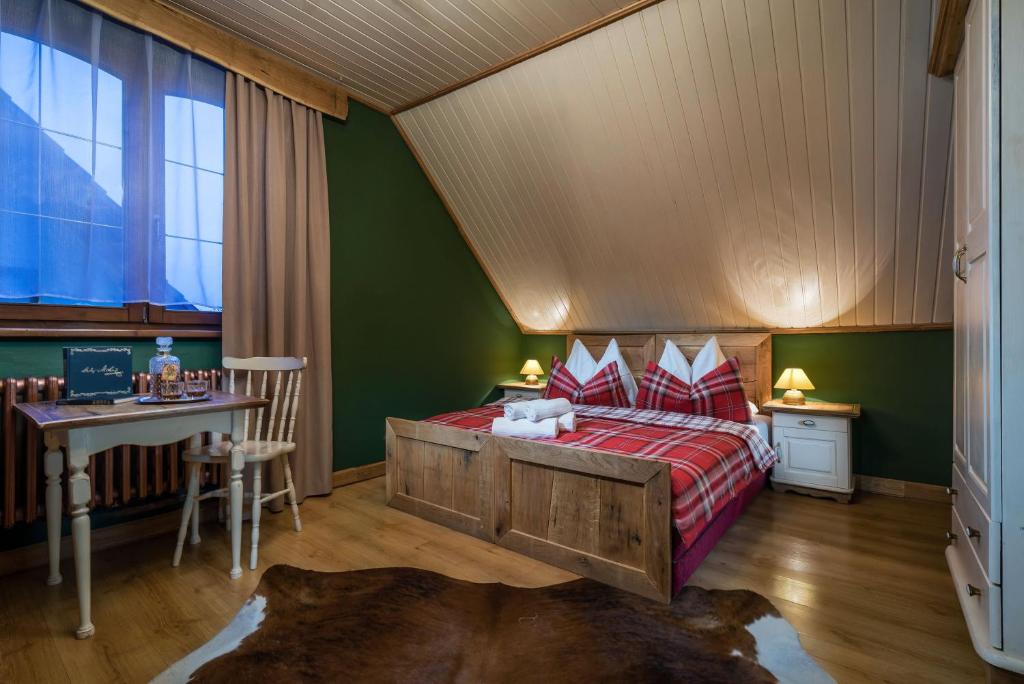 a bedroom with a bed and a table and a desk at Vila House Family in Poprad