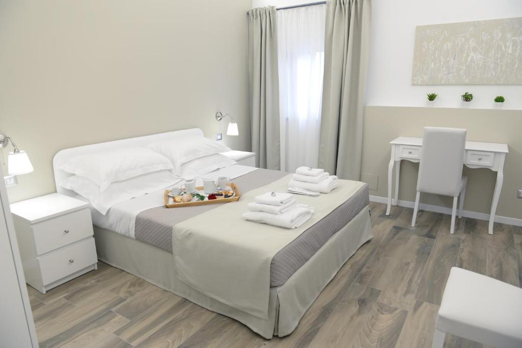 a white bedroom with a bed and a desk at Domus Dams B&B in Montescaglioso