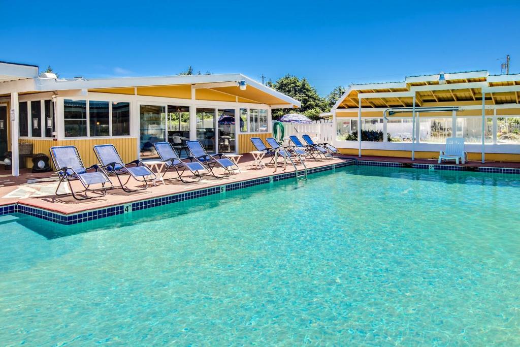 a swimming pool with chairs sitting in the water at Beachwood Condos & Resort in Copalis Beach