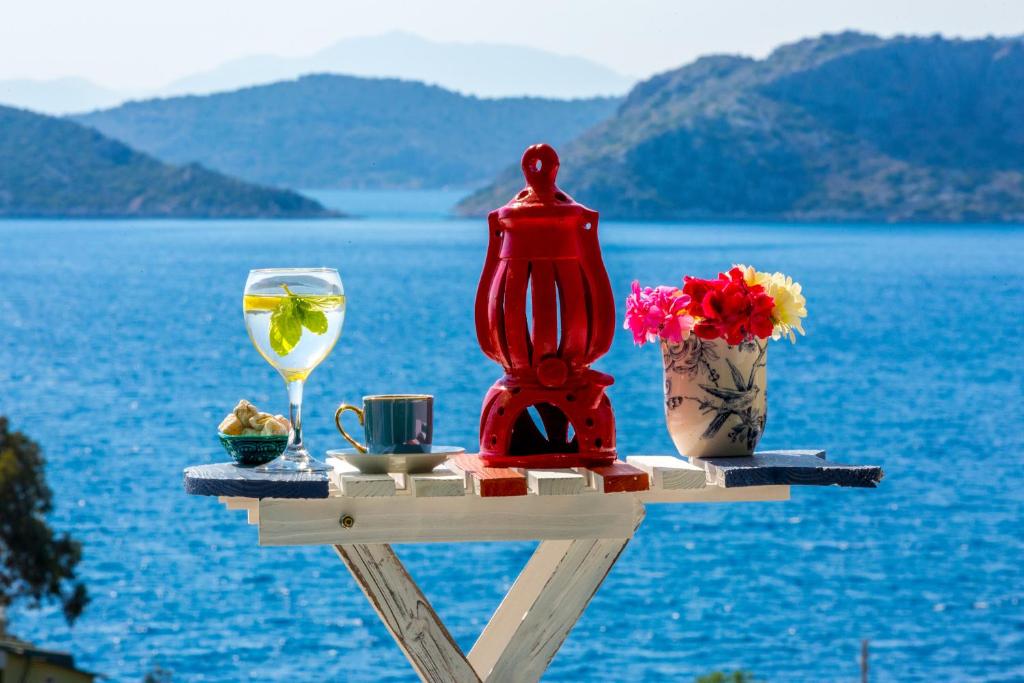 una mesa con una copa de vino y una vela y flores en Derin Mavi Suit Butik Otel, en Sogut