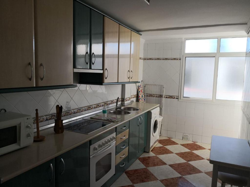 a kitchen with a sink and a stove top oven at Piso Vacacional Isla Cristina in Isla Cristina