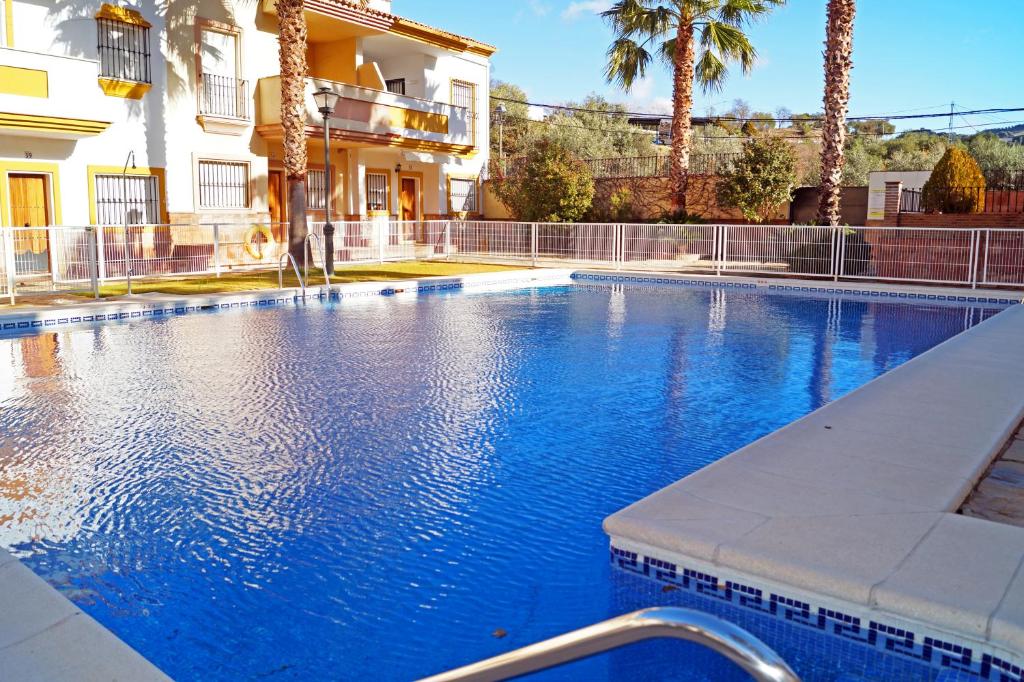 a large blue swimming pool in front of a building at Casa Isabel in Benaoján