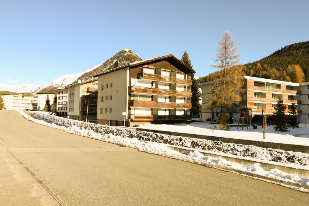 un edificio al lado de una calle cubierta de nieve en Haus Bündabrücke - Mosbacher, en Davos