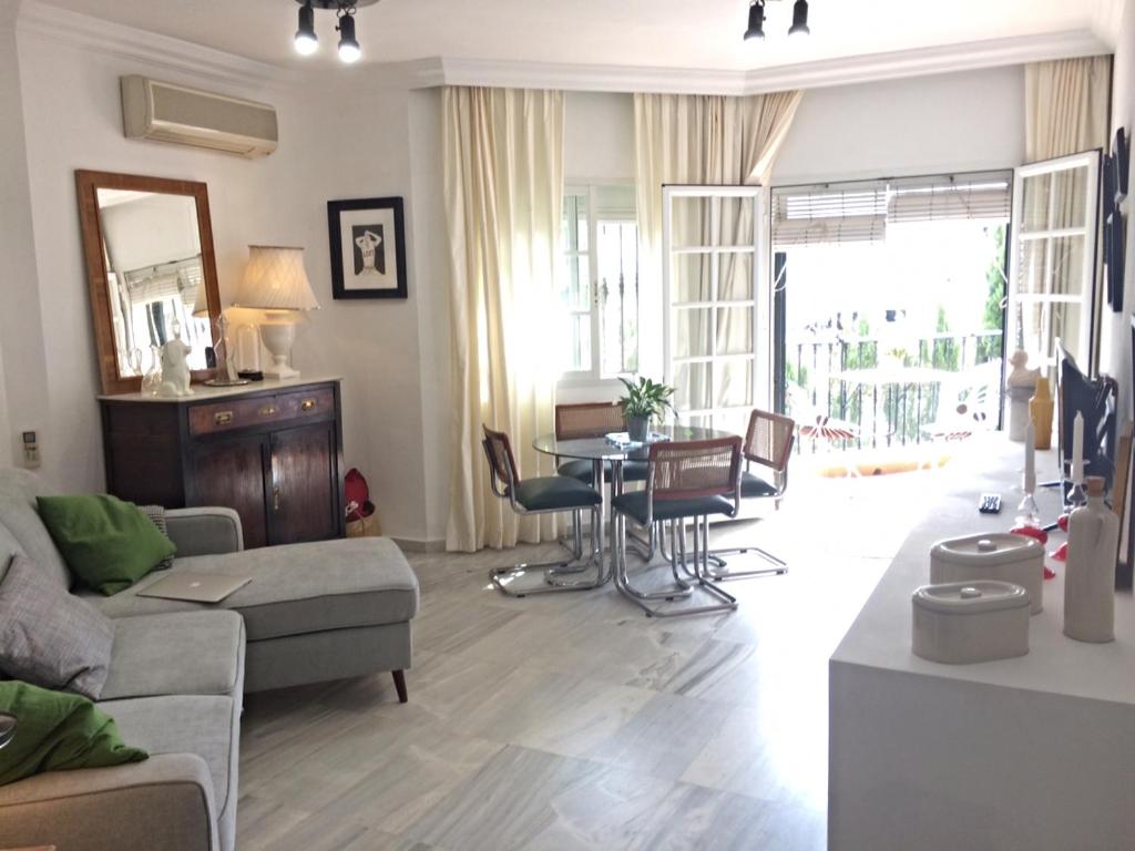 una sala de estar con un sofá y una mesa en Frente al mar, en Benalmádena