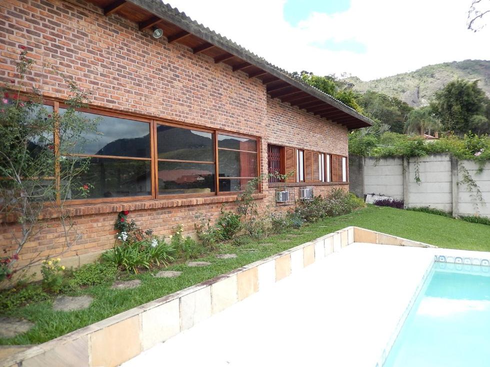 una casa de ladrillo con piscina frente a ella en A MELHOR PROPRIEDADE DA SERRA 6000M2 DE LAZER E ATRACOES IDEAL FAMILIAS COM BEBES E CRIANCAS RESERVA PARTICULAR DE MATA ATLANTICA c PISTA DE CAMINHADA INAUGURADO VEJAM AS FOTOS DESSA E DAS OUTRAS ATRACOES, en Teresópolis