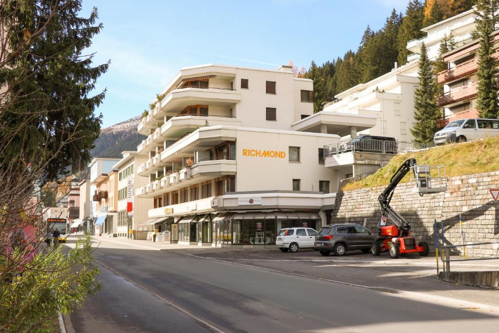 a street with cars parked in front of a building at Richmond - 204 in Davos