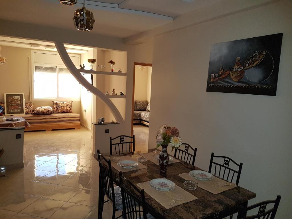 een eetkamer met een tafel en stoelen in een woonkamer bij Appartement de lux 4 chambres in Oujda