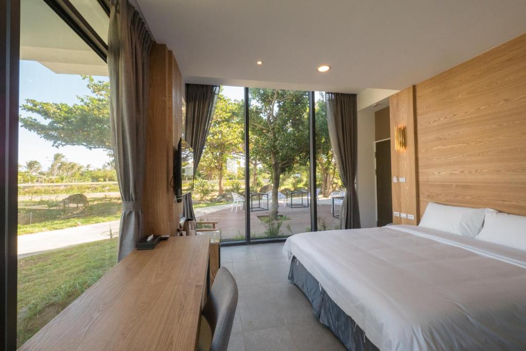 een slaapkamer met een groot bed en een groot raam bij Okra Villa in Kenting