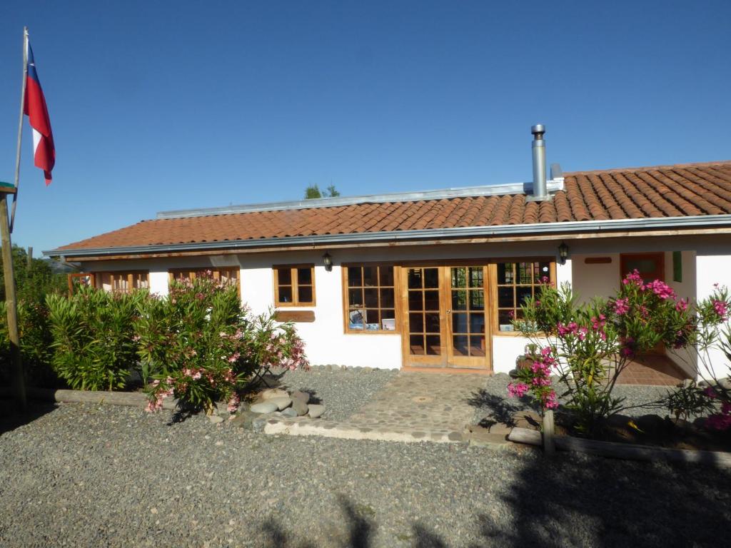 a white house with flowers in front of it at La Maravilla Lodge in Vilches