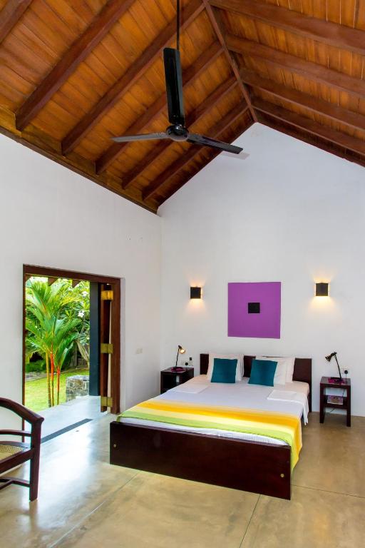 a bedroom with a large bed and a ceiling at Palm Paradise Cabanas & Villas Beach Resort in Tangalle