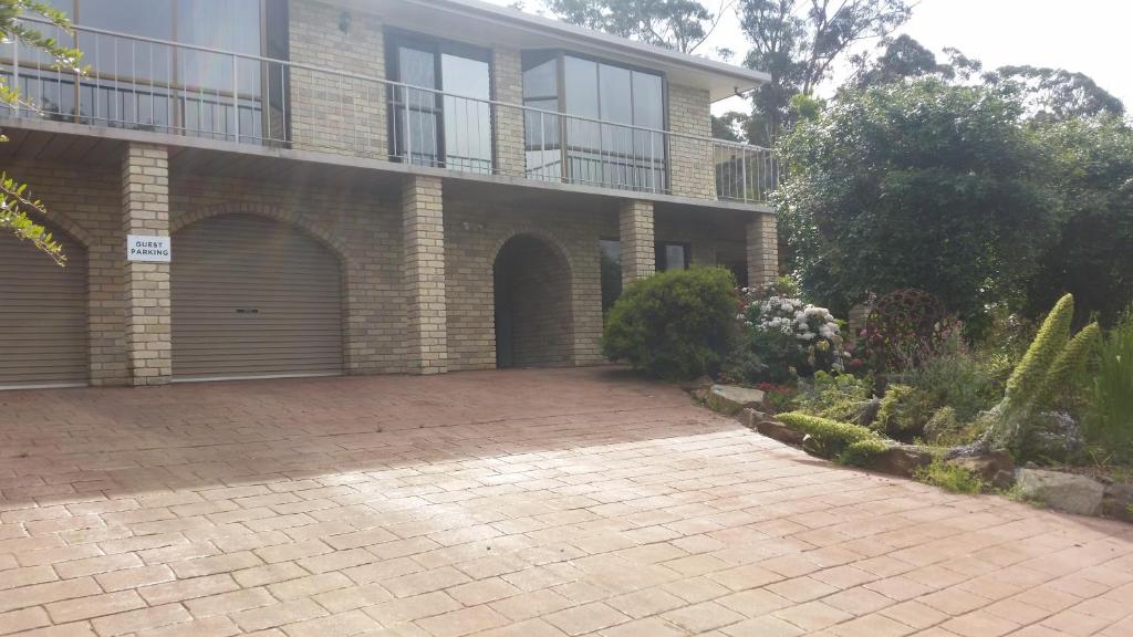 a brick house with a balcony and a brick driveway at Beezneez B&B in Orford