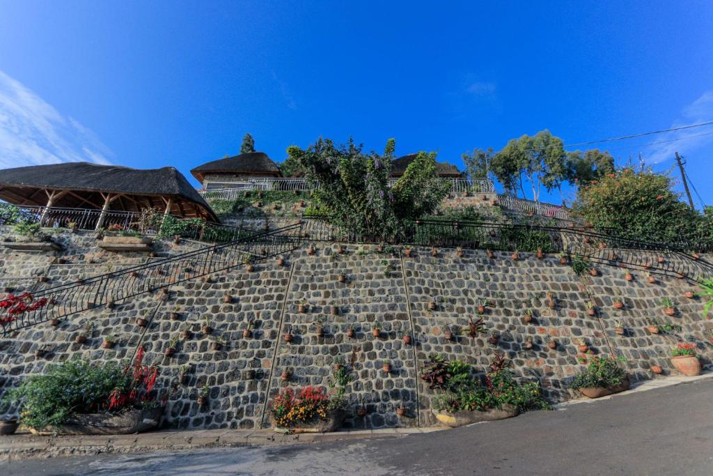een stenen muur met potplanten erop bij Hakuna Matata Lodge in Gisenyi