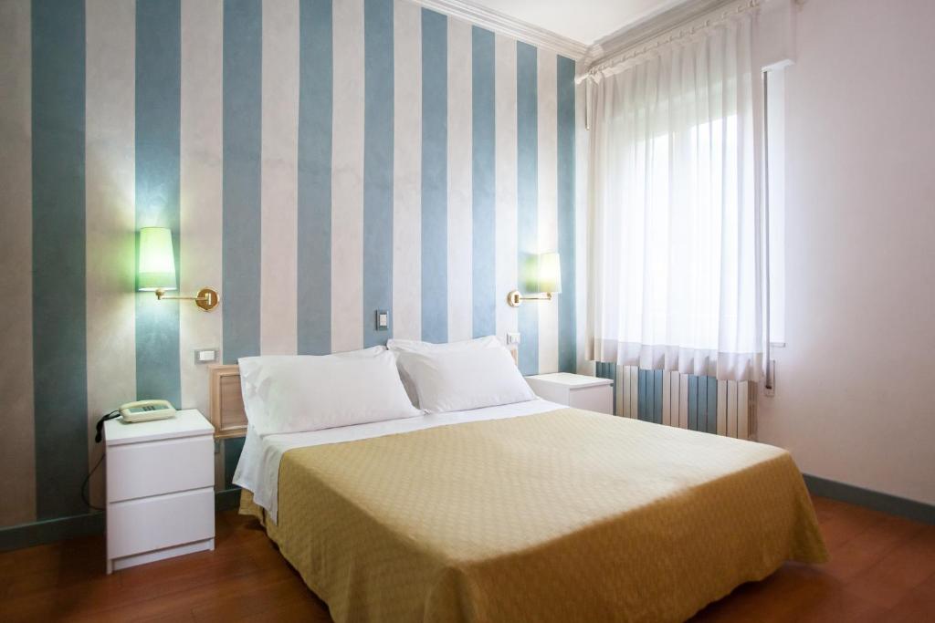 um quarto com uma cama grande e uma janela em Hotel Diana em Ravenna