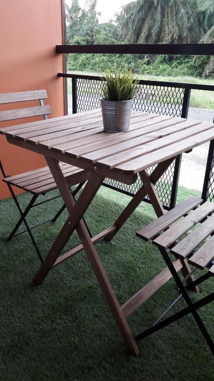 a wooden picnic table with a potted plant and a bench at Jeram Tiny House in Jeram