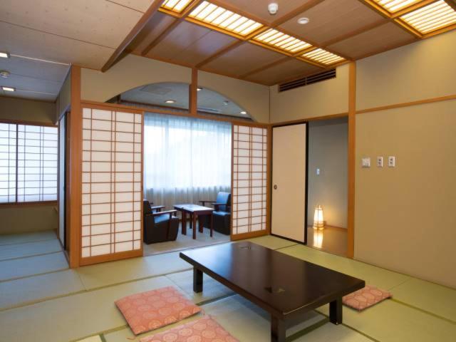澀川市的住宿－伊香保大酒店，带桌子的客房位于带窗户的房间内