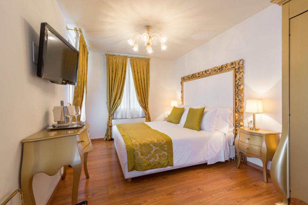 a bedroom with a bed and a tv and a mirror at Al Bailo Di Venezia in Venice