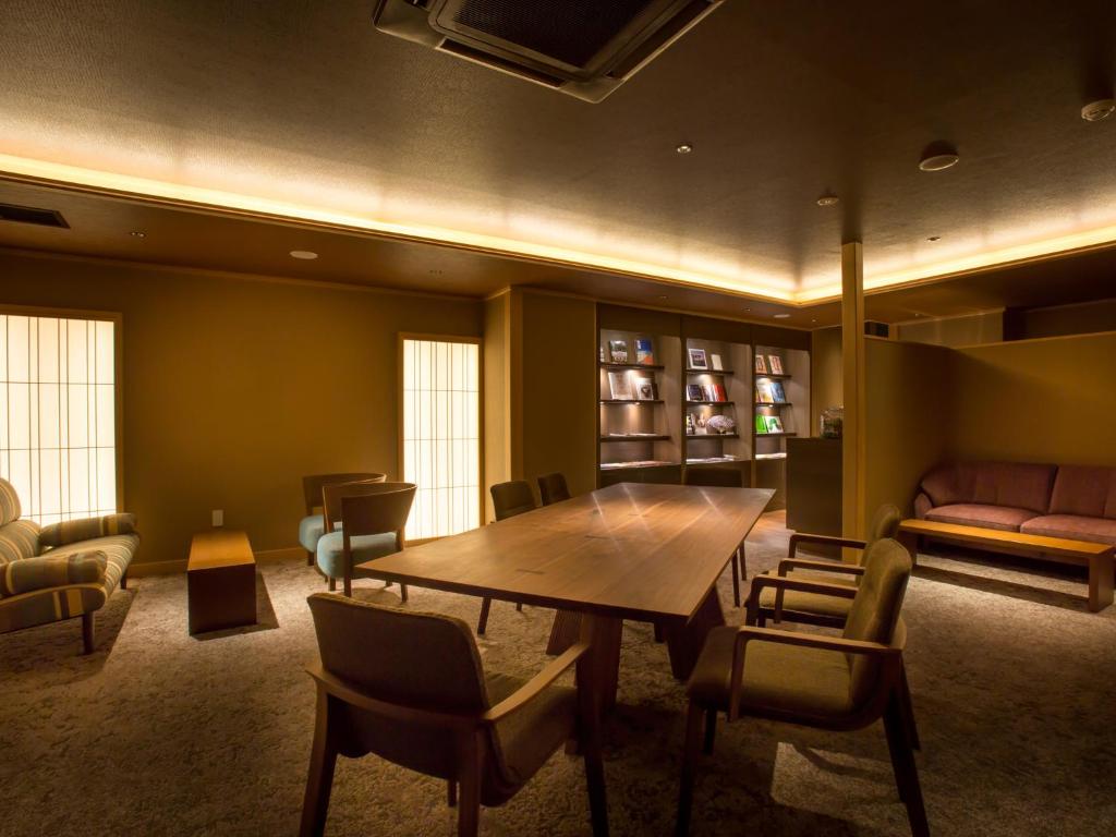 a dining room with a wooden table and chairs at Saka Hotel Kyoto in Kyoto