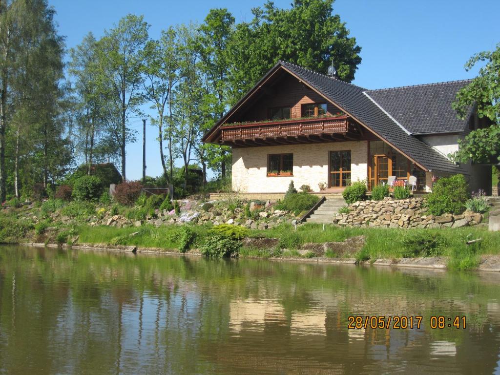 ein Haus neben einem Fluss mit einem Haus in der Unterkunft Chalupa Zlate Pisky in Nové Křečany