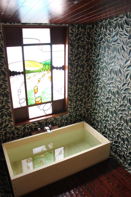 a bathroom with a bath tub and a window at Tsukihitei in Nara