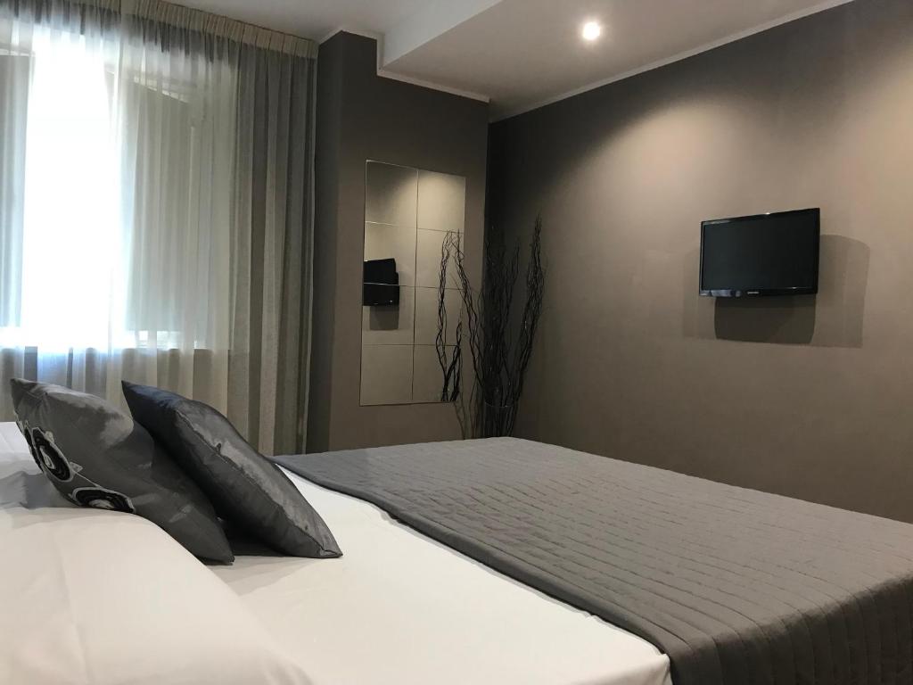 a bedroom with a bed with a tv on the wall at Di Martino Residence in Rome