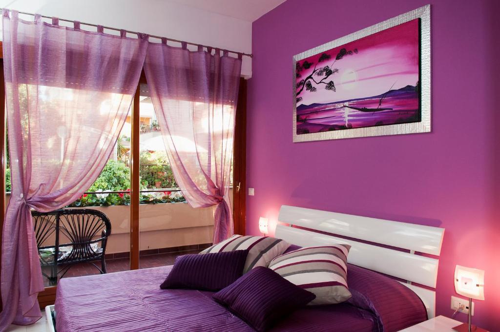 Dormitorio púrpura con cama y ventana en La Casetta del Vaticano en Roma