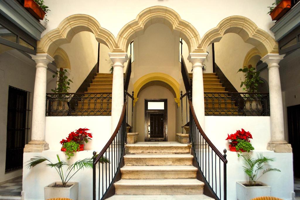 a staircase in a building with red flowers at Apartamentos Larga 70 in El Puerto de Santa María