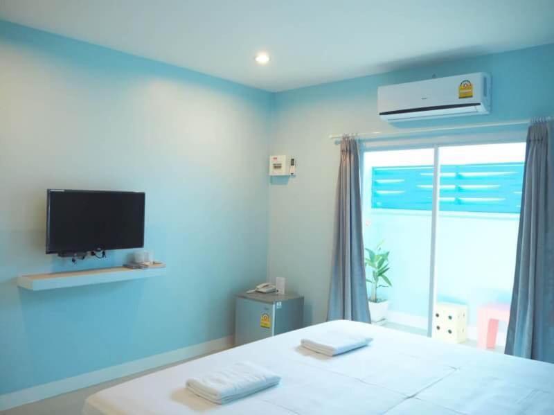 佛丕的住宿－SB Inn，一间蓝色的卧室,配有一张床和一台墙上的电视