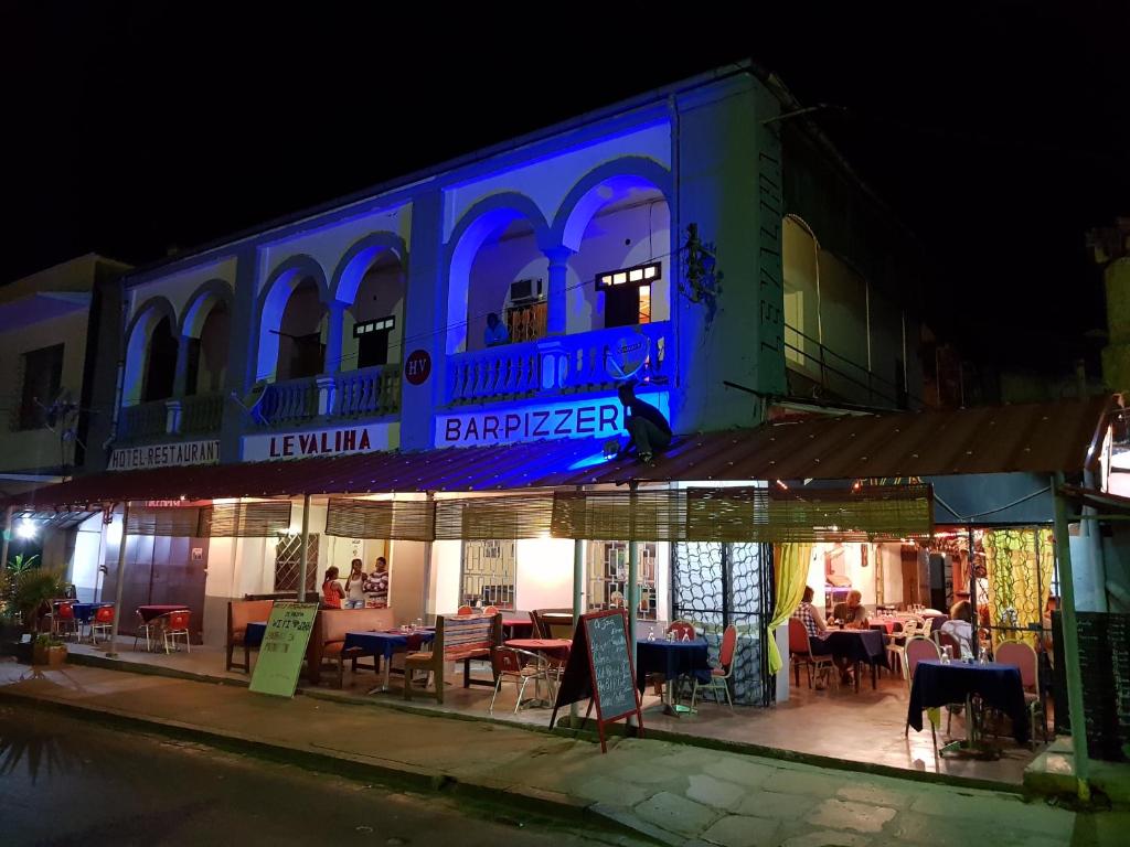 a restaurant with a blue sign on the side of a building at Hotel Valiha in Antsiranana