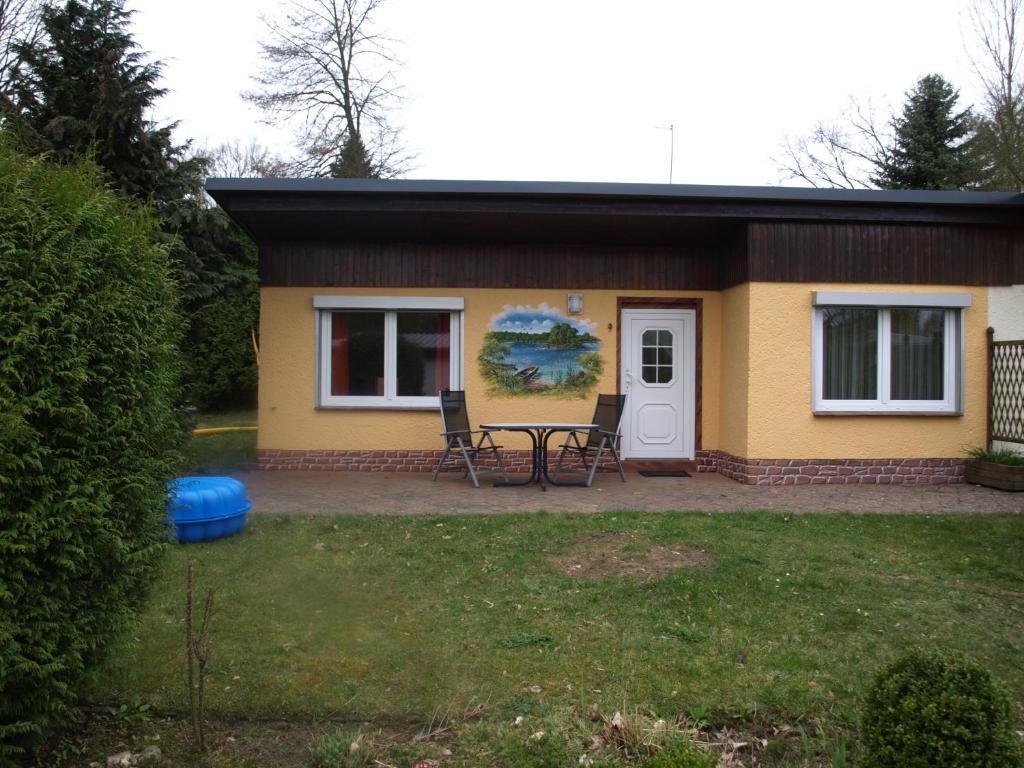 ein kleines gelbes Haus mit zwei Stühlen und einem Tisch in der Unterkunft Haus 9 in Schwarz