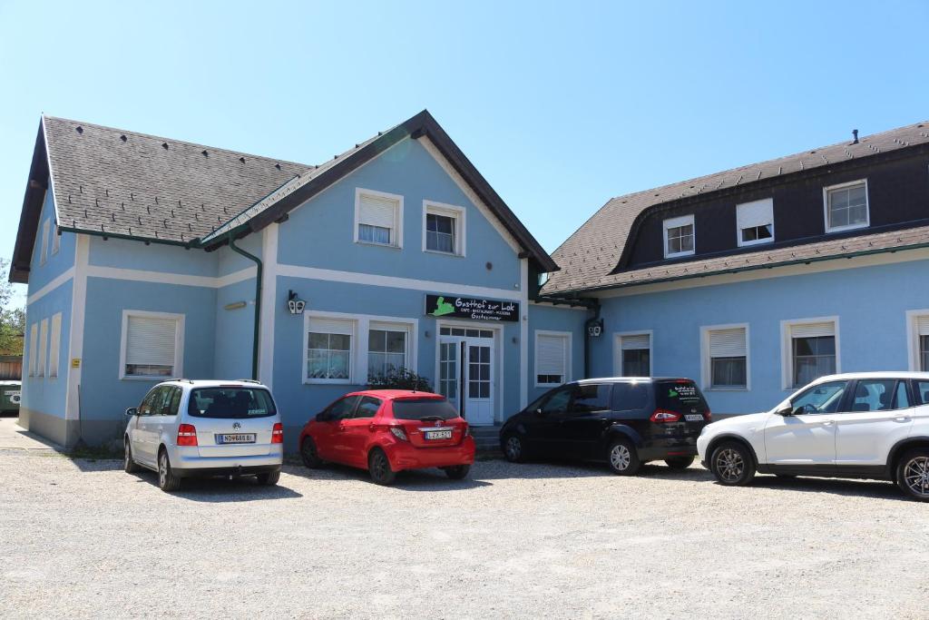 a blue building with cars parked in a parking lot at Lei's WOK in Neusiedl am See