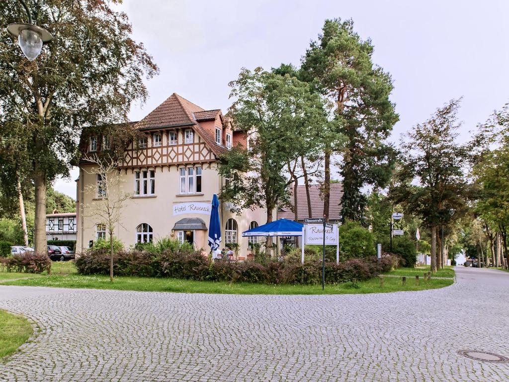una casa en una calle frente a un edificio en Hotel Villa Raueneck, en Bad Saarow