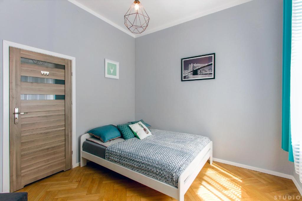 ワルシャワにあるClickTheFlat Wspólna Central Apart Roomsの小さなベッドルーム(ベッド1台、ドア付)