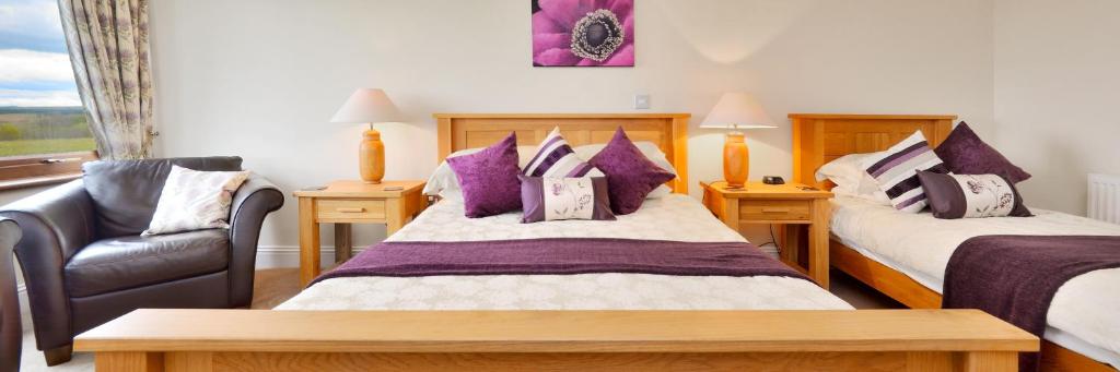 1 dormitorio con 2 camas, silla y ventana en Peggyslea Farm B&B en Edimburgo