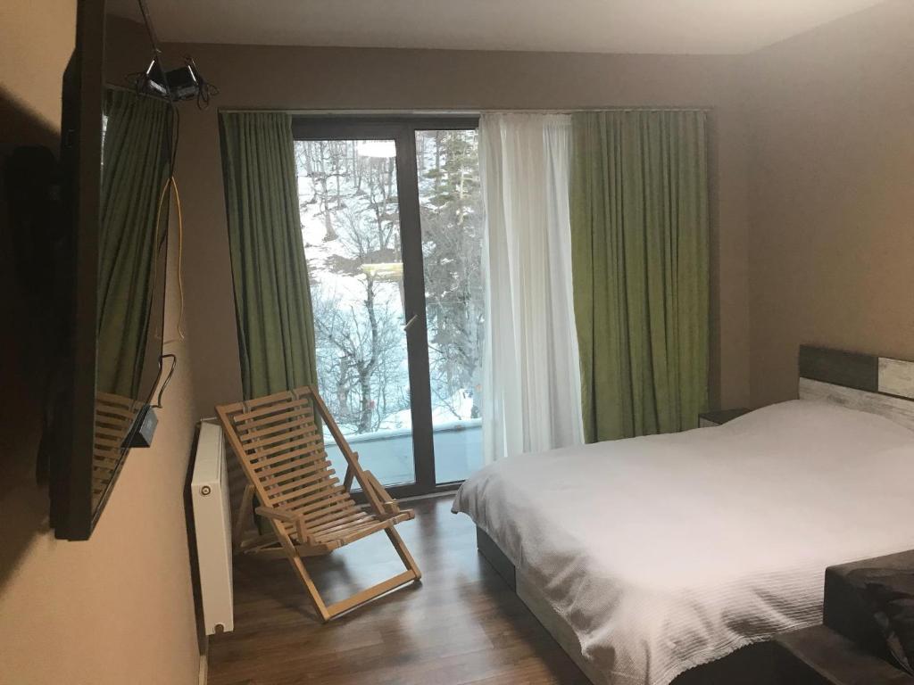 ein Schlafzimmer mit einem Bett und einem Stuhl neben einem Fenster in der Unterkunft The valley 309 in Nariani