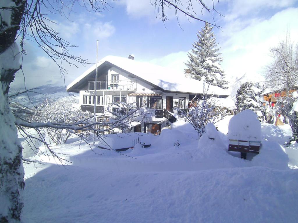 una casa cubierta de nieve delante en Fortuna en Bürchen
