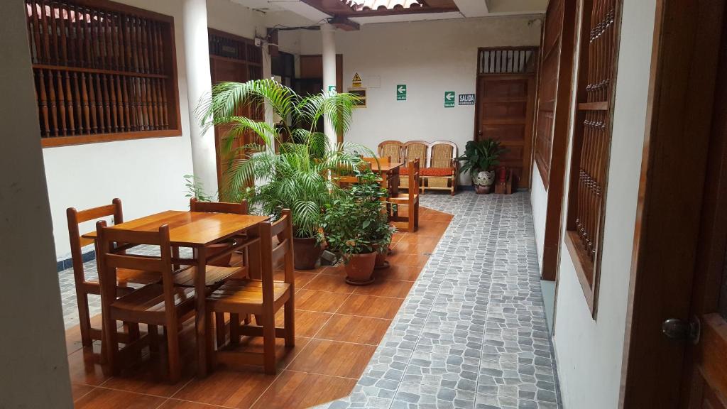 un comedor con mesas, sillas y macetas en Amazon Green Hotel, en Iquitos