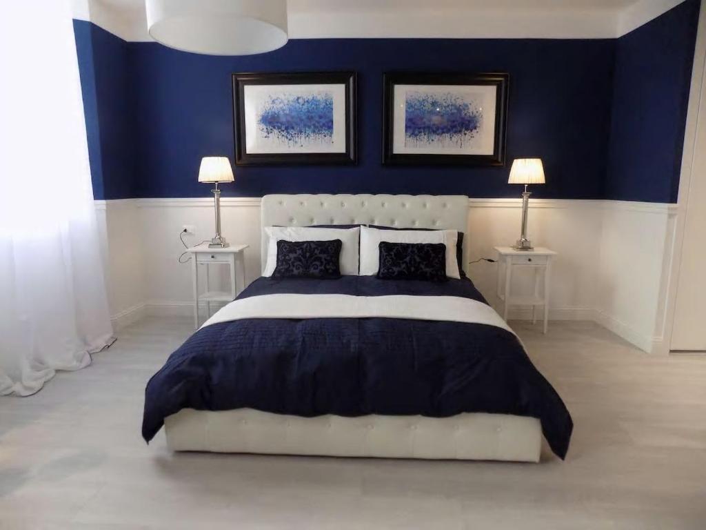 プラートにあるHs4U The Blue Charm Suite apartmentのベッドルーム1室(青い壁のベッド1台、ランプ2つ付)