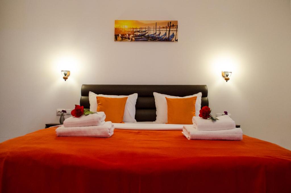 - une chambre avec un lit rouge et des serviettes dans l'établissement City Lux Villa, à Bucarest