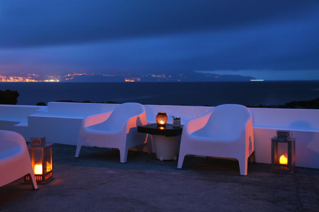 un gruppo di sedie e un tavolo con luci di Pocinhobay a Madalena