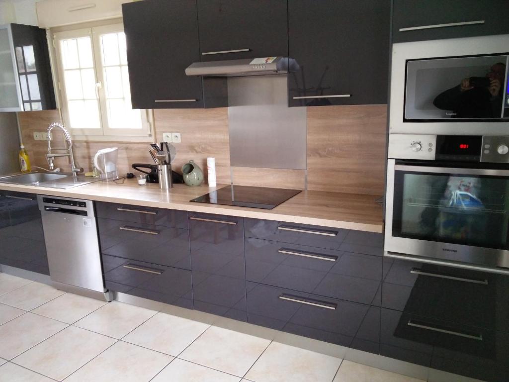 a kitchen with a sink and a microwave at Gîte La Cavée in Le Bourg-Dun