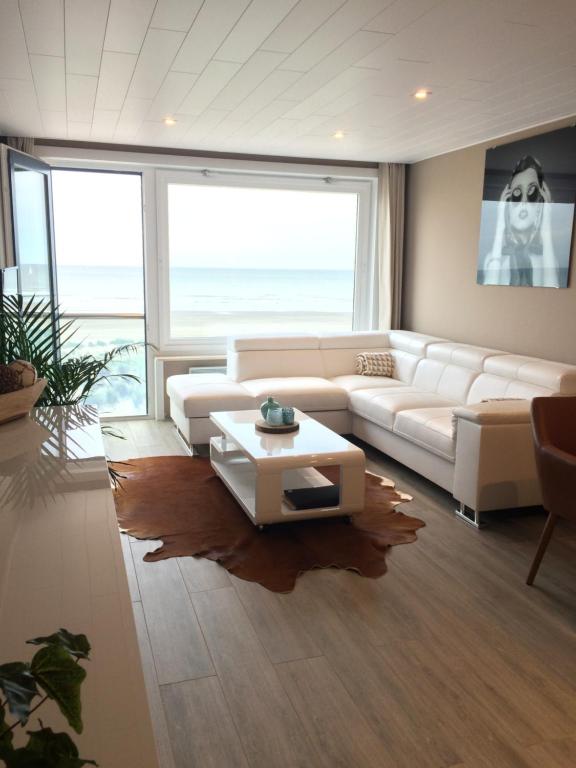 a living room with a white couch and a table at Zonnestraal 0302 in Nieuwpoort