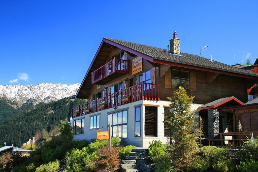 a house on a hill with mountains in the background at Matterhorn Lodge in Queenstown