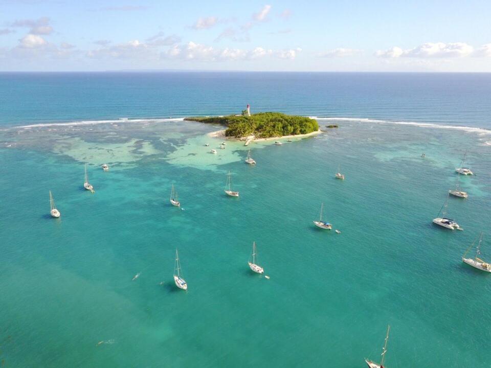 an island in the ocean with boats in the water at Jolibois Lodge & Spa in Le Gosier