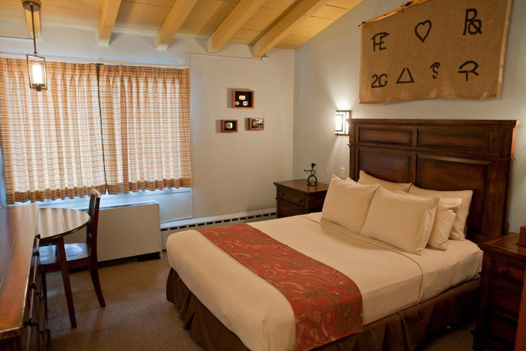 a bedroom with a bed and a table and a window at Dude Rancher Lodge in Billings