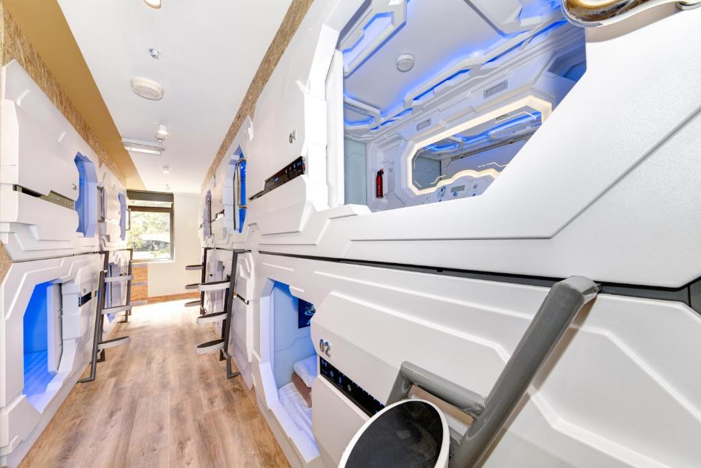 an empty hospital room with blue and white walls at Space Q Capsule Hotel in Sydney