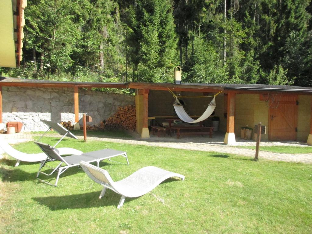 Hnilčík的住宿－Villa Cechy，院子里的一组椅子和吊床