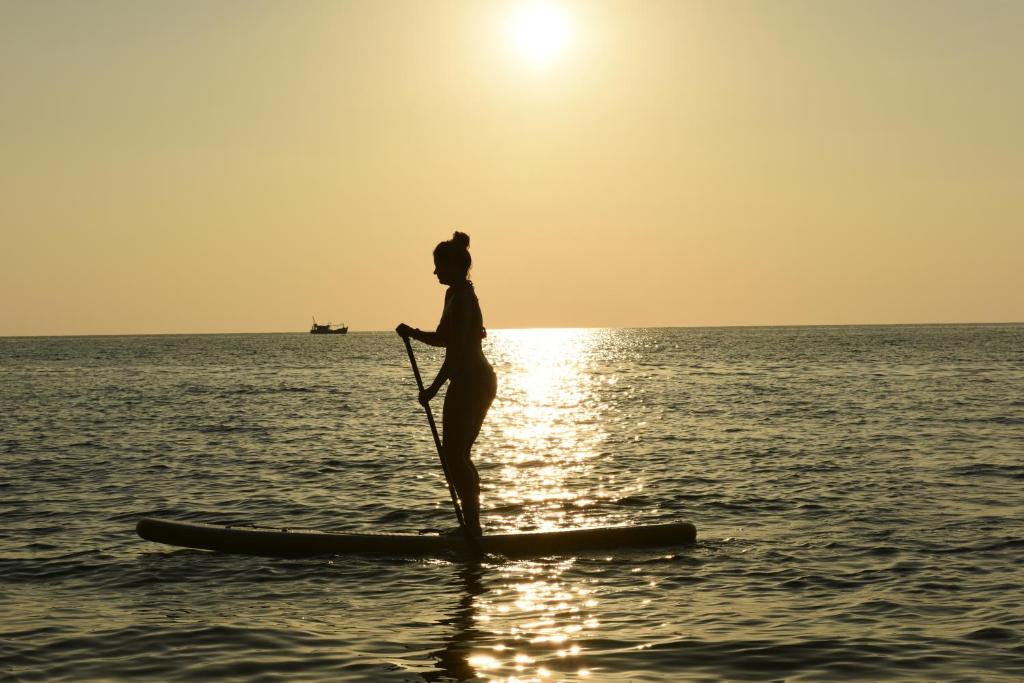 
a person riding a surfboard on top of a body of water at Robinson Bungalows in Koh Rong Sanloem
