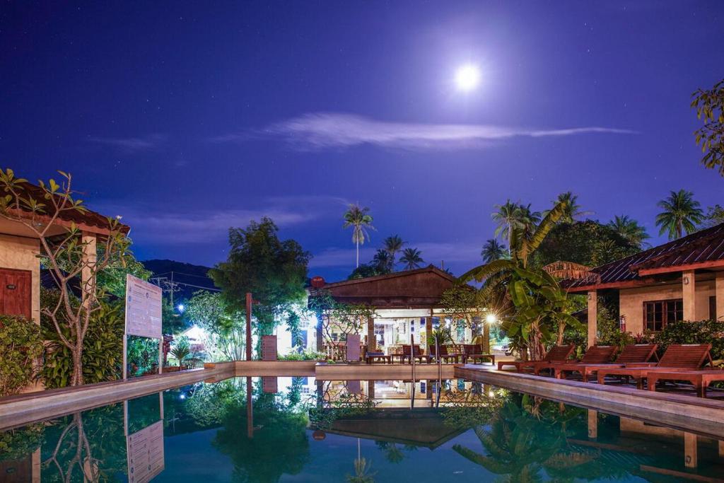 a pool at night with the moon in the sky at Beck's Resort in Haad Pleayleam