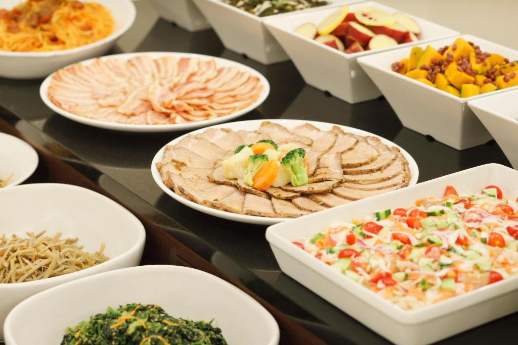 a table with many plates of food on it at HOTEL MYSTAYS Kanazawa Castle in Kanazawa