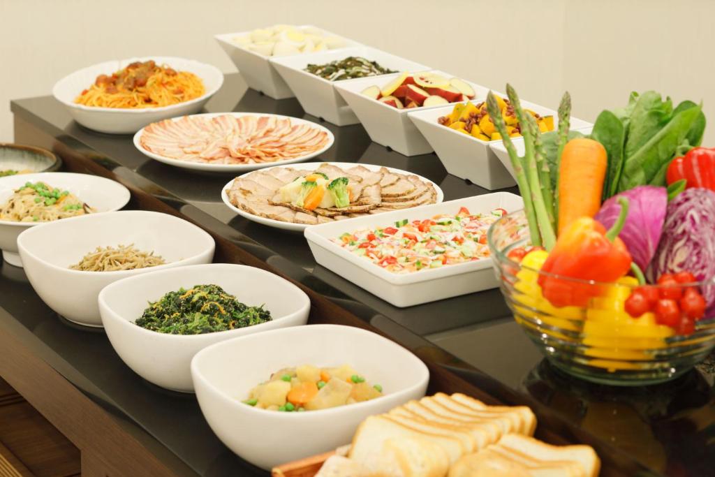 a table topped with bowls of different types of food at HOTEL MYSTAYS Kanazawa Castle in Kanazawa
